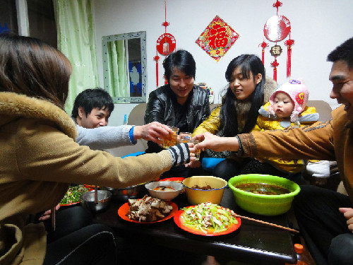 除夕夜全家人聚在一起热热闹闹吃团圆饭是中国人过春节的传统习俗