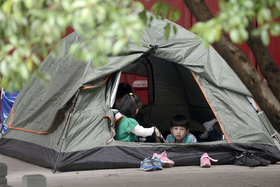 两名在杭州青少年活动中心参加培训班的孩子在家长支起的帐篷里午休