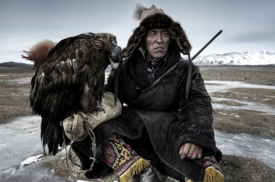 摄影 猎人/在蒙古西部的广袤平原上，穿着传统服饰的猎人正在休息，准备下...