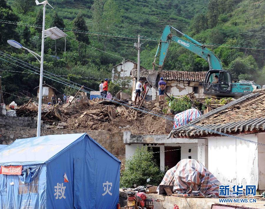 138月24日,鲁甸地震震中龙头山镇龙泉村的受灾群众在清理废墟.