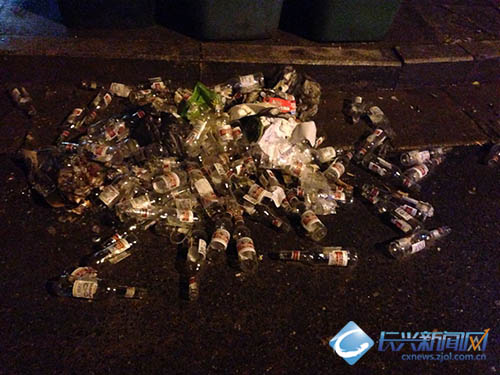 一堆啤酒瓶躺在垃圾桶前 文明只在一步间(图