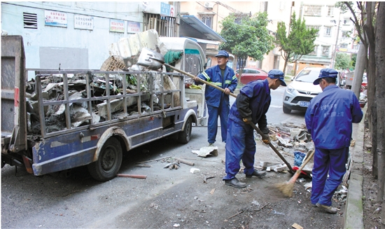 卧龙山庄社区,3名环卫工人正在清运卫生死角垃圾.