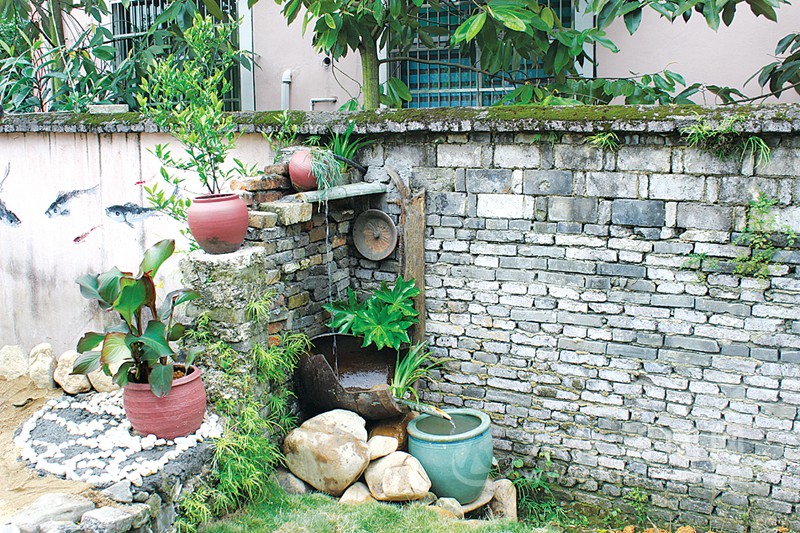 篱笆,石子路的装扮随意又精巧,古朴的瓦罐和绿植将小小的庭院延展到了
