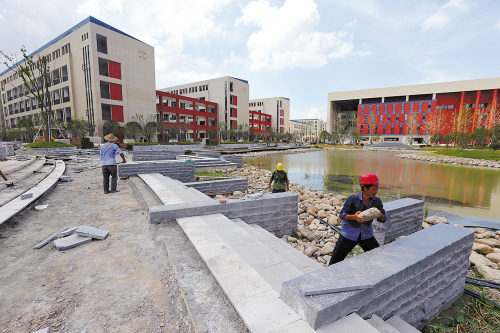 图为工人正加紧修建北师大台州附属高级中学配套景观设施.