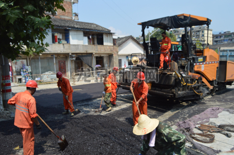 林化路市政工程施工现场,施工人员正顶着烈日争分夺秒地施工建设