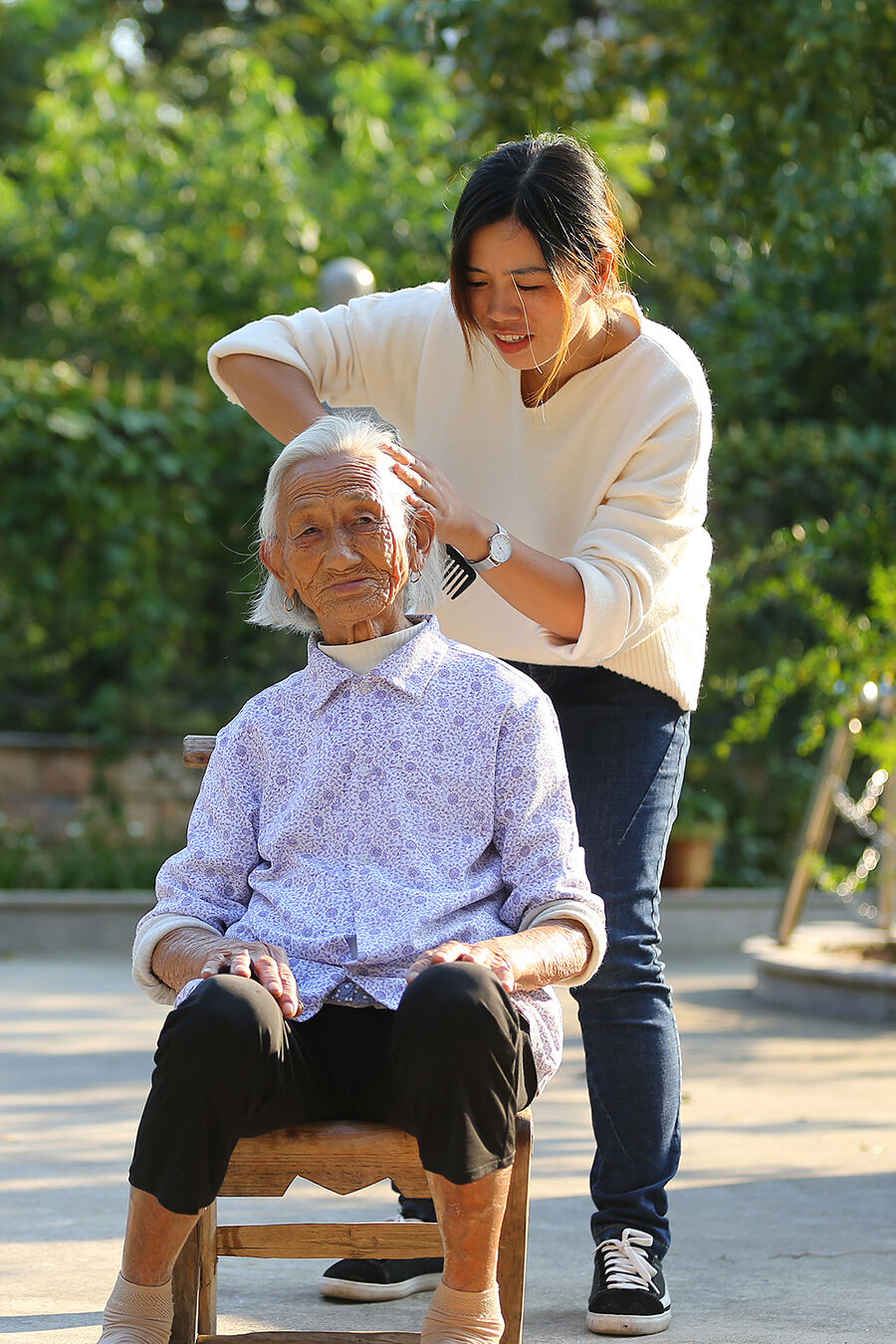 泗安镇云峰村,村妇女主任邱金红正在为老寿星梳理头发,画面十分暖心