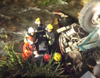渣土車側翻掉入溪中，為防駕駛員浸泡，消防員讓水改道