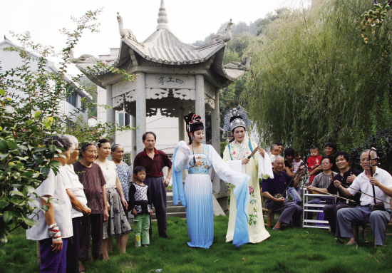 越剧发源地甘霖镇施家岙村宗祠前的"四工亭",戏迷们穿起戏服用"四工调