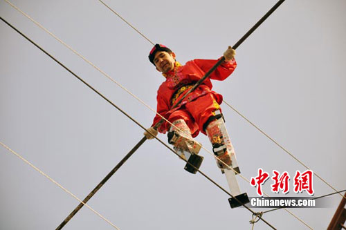 新疆男子踩60厘米高跷在12米的高空走钢丝