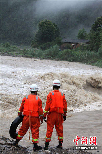 图为面对湍急的河流,救援人员正在商讨过河对策。 赵渊盛 摄