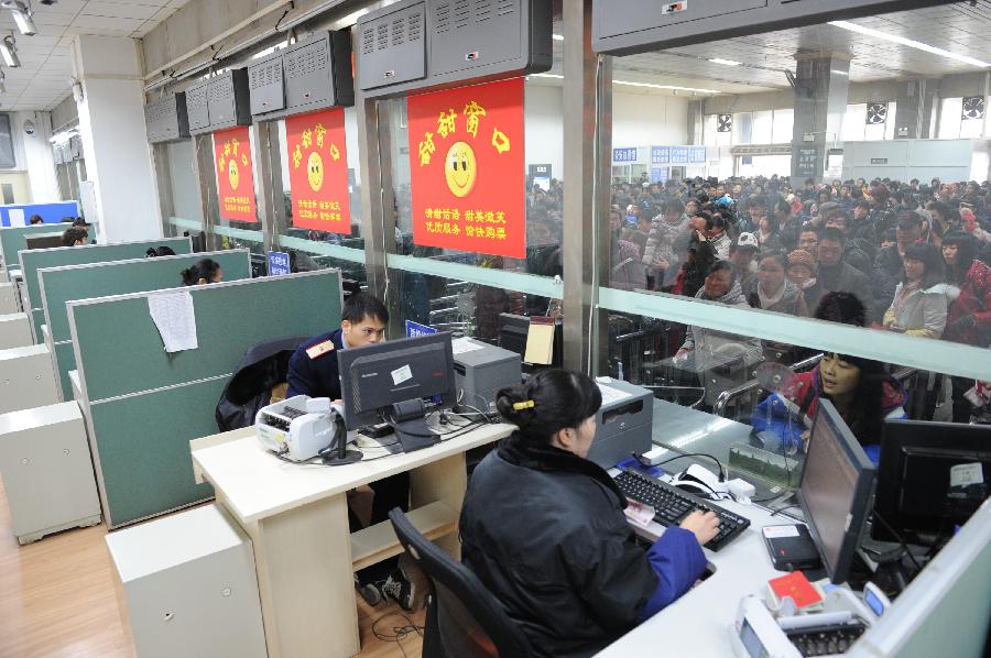 1月7日,贵阳火车站售票窗口工作人员为旅客发售火车票.