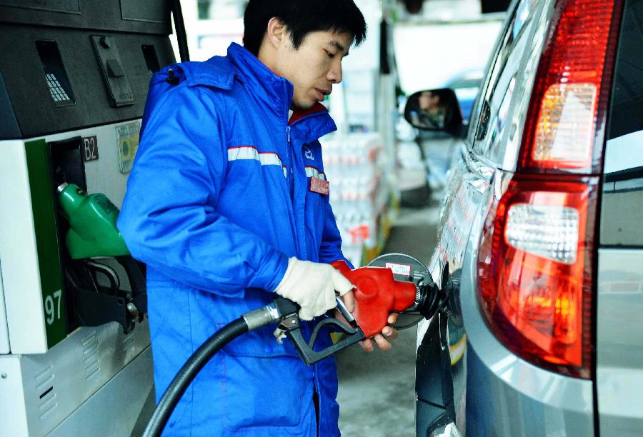 2月24日,杭州一家加油站的员工在为一辆汽车加油.新华社发