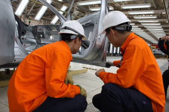 圖為成都工廠焊接車間,兩位焊裝工人在檢查焊點