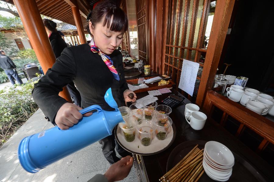 "开心茶馆"里的茶杯不够用,服务员只能用塑料杯子给客人泡茶(3月14