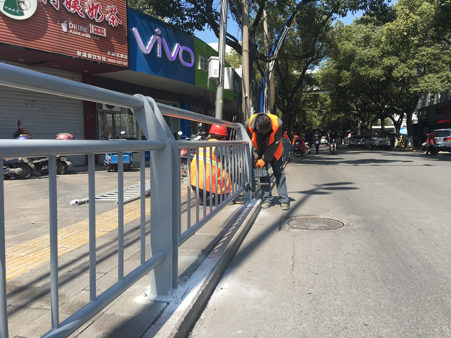 昨天,在縣城車站路和解放路交叉口,幾名工人正在道路旁安裝隔離護 