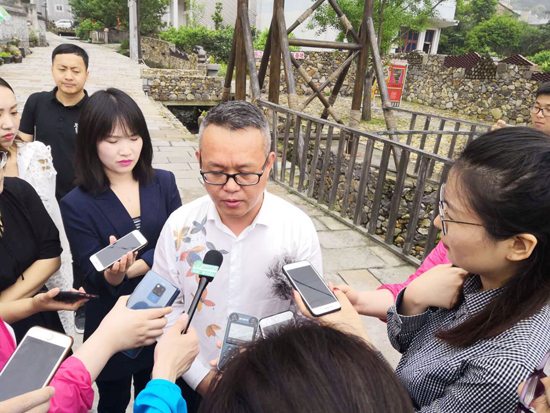 在温岭坞根镇花溪村,温岭市坞根镇宣统委员叶伟建被记者们团团围住