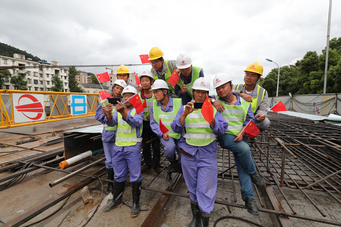 杭州地铁3号线建设者在施工现场用手机观看庆祝大会直播.