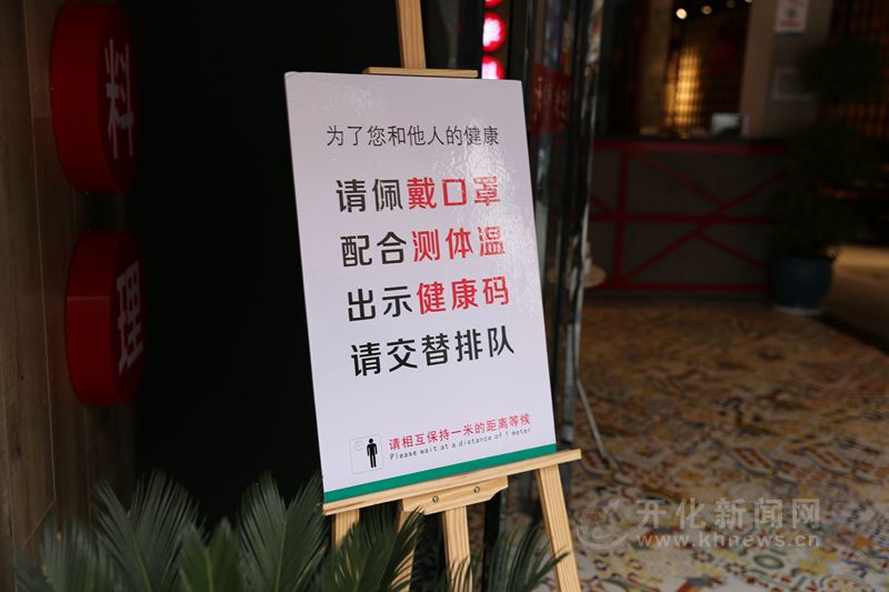 只见正门处放置了醒目的"公筷公勺"提示牌,进店人员必须测体温,查看