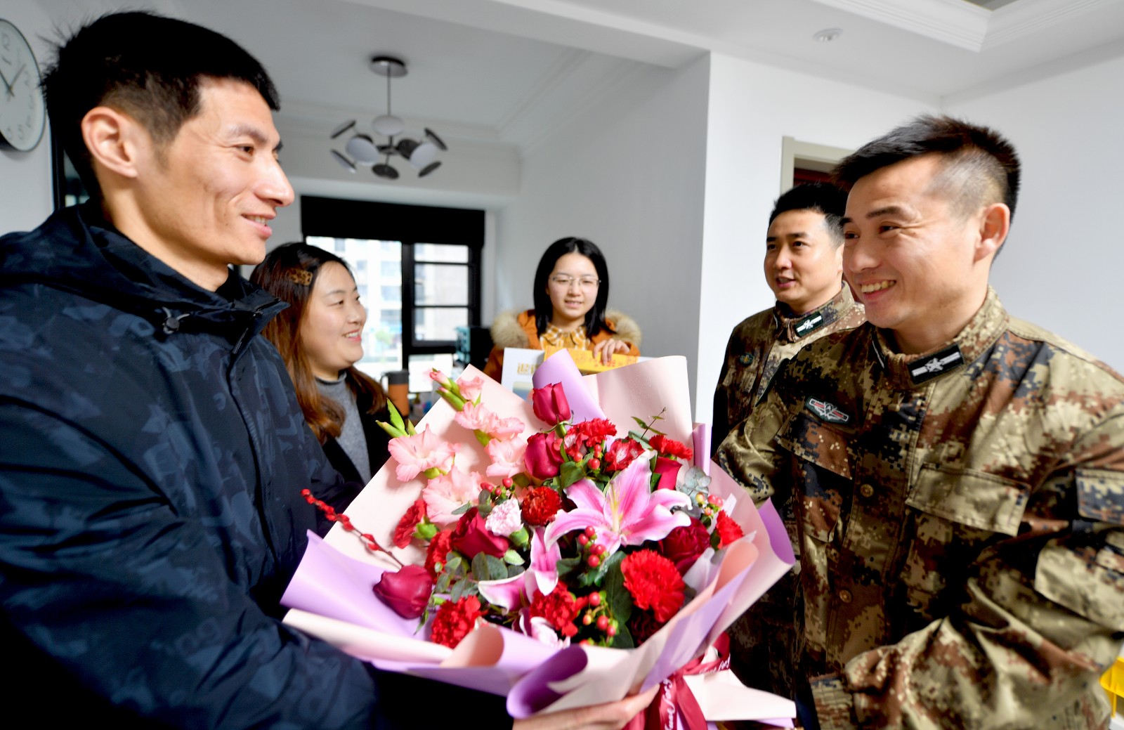 把鮮花,榮譽證書等送到星光耀小區轉業軍人徐小強手中